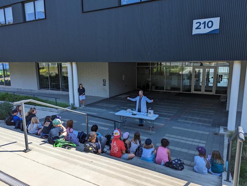 Children sitting on stairs watching chemistry show